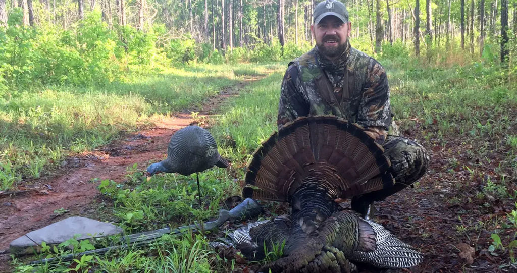 A photo of the author with a public land turkey he killed using the tips and tricks in this article.