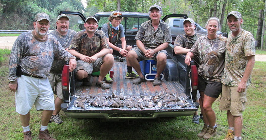 A group of dove hunters with a limit of dove on the tailgate.