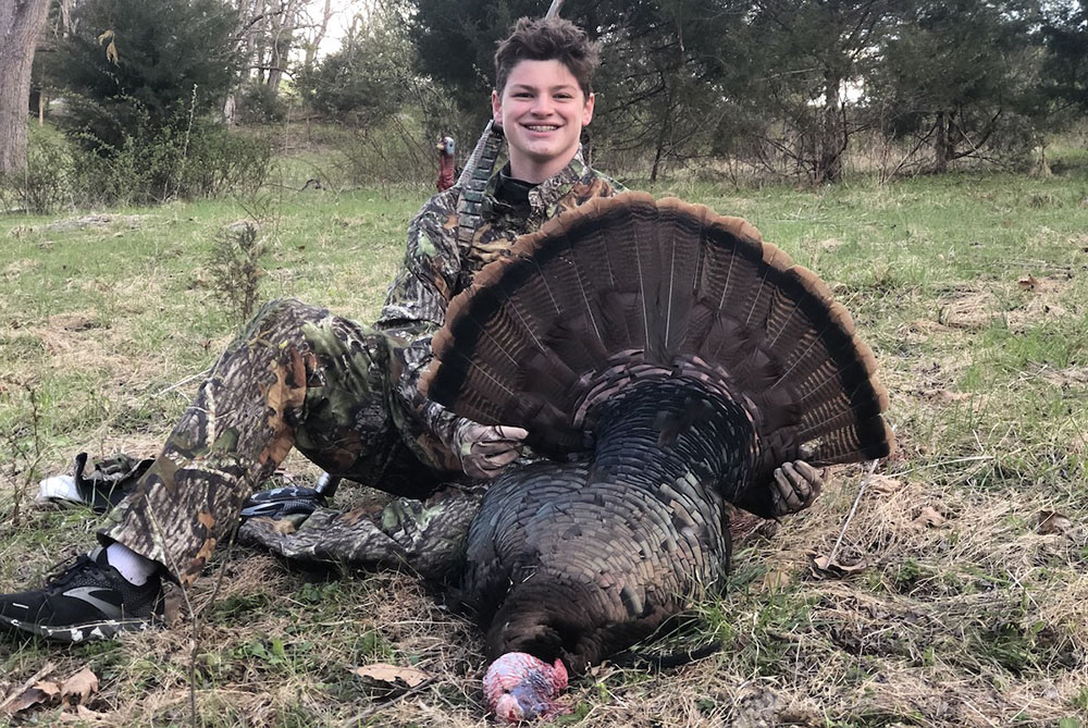 A successful youth turkey hunter with his harvest.